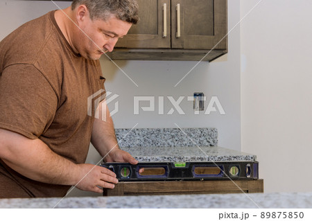 Professional worker assembling leveling countertop for cabinet Professional worker assembling leveling countertop for cabinet 89875850
