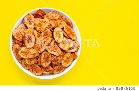 Banana slice chips on yellow background. Banana slice chips on yellow background. 89876159