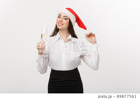 Christmas Celebration - Young beautiful business woman celebrating christmas with glass of champagne. 89877561