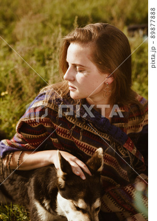 close-up. Profile of a beautiful girl with natural beauty sitting among the grass in a hug with a dog close-up. Profile of a beautiful girl with natural beauty sitting among the grass in a hug with a dog 89877888