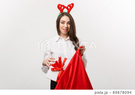 Christmas Concept - Young beautiful business woman happy with present in santa bag. 89878094