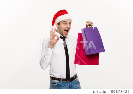 Christmas Concept - Handsome Business man celebrate merry christmas and happy new year wear santa hat with Santa red big bag. Christmas Concept - Handsome Business man celebrate merry christmas and happy new year wear santa hat with Santa red big bag. 89878425