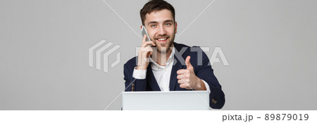 Business Concept - Portrait Handsome Business man showing thump up and smiling confident face in front of his laptop. White Background.Copy Space. 89879019