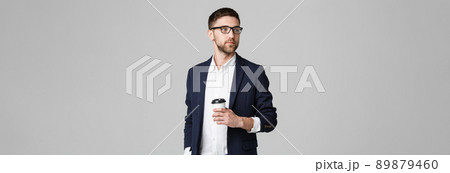 Portrait of a handsome businessman in eyeglasses with a cup of coffee. 89879460
