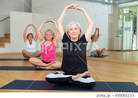 Group of aged ladies sitting in lotus pose Group of aged ladies sitting in lotus pose 89880233