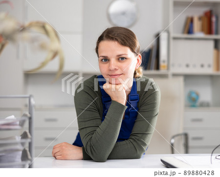 Young female cleaner working productively on task in office 89880428