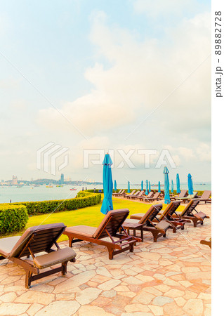 chair pool or bed pool and umbrella around swimming pool with sea beach background chair pool or bed pool and umbrella around swimming pool with sea beach background 89882728