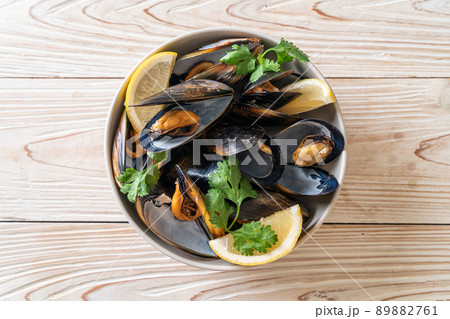 Mussels with herbs in a bowl with lemon 89882761