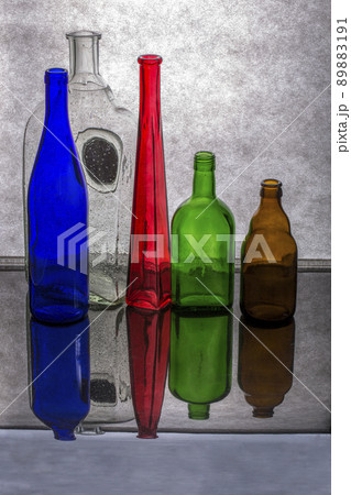 Still life with glass multicolored dishes on a gray background 89883191