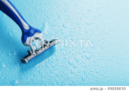 Razor blades on a blue background with drops of icy water 89888630