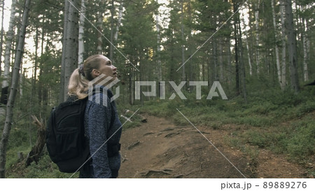 Traveler photographing scenic view in forest. One caucasian woman shooting nice magic look. Girl take photo video on dslr mirrorless camera. 89889276