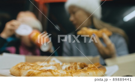 Mother and daughter eat pizza cheese four. Close up of young woman eating pizza and chewing in outdoor restaurant. Girl hands taking pieces pizza. Mother and daughter eat pizza cheese four. Close up of young woman eating pizza and chewing in outdoor restaurant. Girl hands taking pieces pizza. 89889441