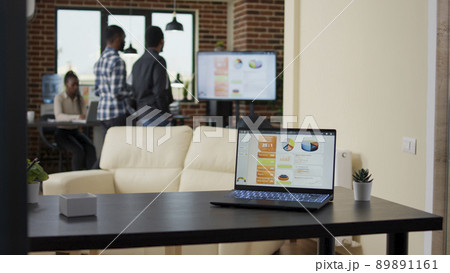 Company office with business charts and graphs on laptop screen, people using profit statistics and sales analysis on financial diagram. Data presentation for project planning. 89891161
