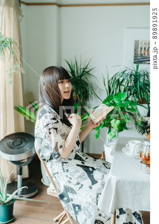 自室で読書を楽しむ若い女性 89891925