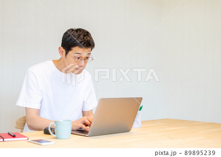 パソコンに目を近づけて仕事をする男性 パソコンに目を近づけて仕事をする男性 89895239
