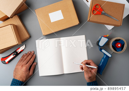 Above table top view of warehouse preparing post courier delivery package Above table top view of warehouse preparing post courier delivery package 89895457