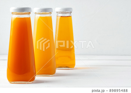 Glass bottles of different juices on white background 89895488