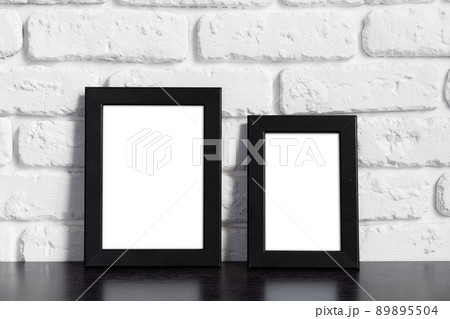 Photo frame with copy space against white brick wall Photo frame with copy space against white brick wall 89895504