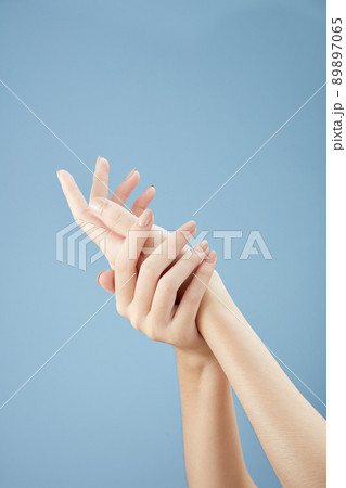 A front view of hand posing in blue background for cosmetic advertising 89897065