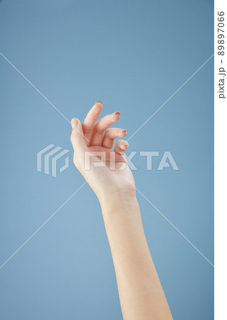 A front view of hand posing in blue background for cosmetic advertising 89897066