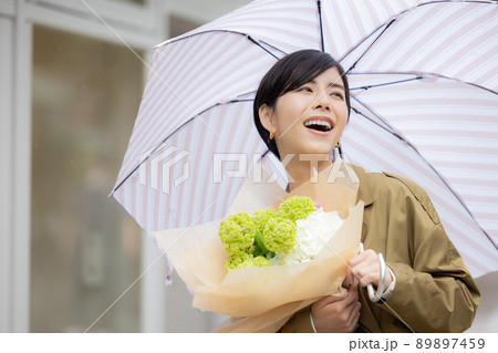 雨の日　紫陽花を持って歩く女性 89897459