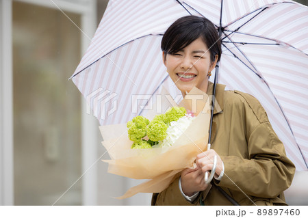 雨の日　紫陽花を持って歩く女性 89897460