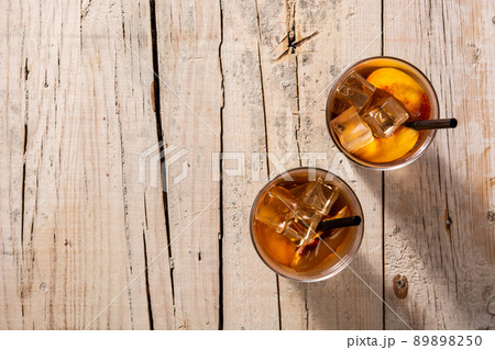 Glass of peach tea with ice cubes 89898250