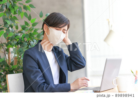 頭痛に苦しむマスクの女性1 89898941