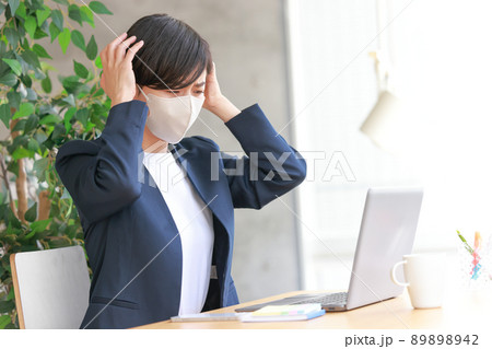 頭痛に苦しむマスクの女性2 89898942