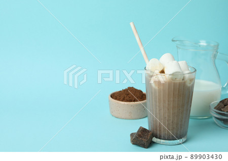 Concept of tasty drink with cocoa on blue background Concept of tasty drink with cocoa on blue background 89903430