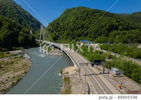 Cable-Stayed Bridge on the Adler-Krasnaya Polyana motorway. Aerial view of car driving along the winding mountain road in Sochi, Russia. 89905596