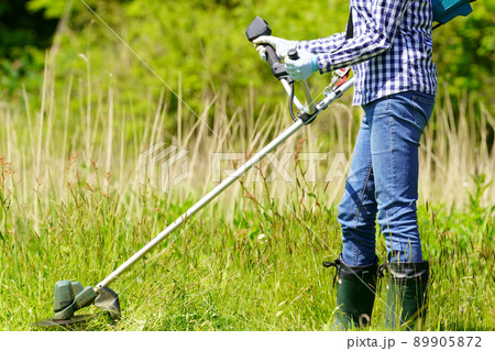 電動草刈り機を操作する女性 顔無し 電動草刈り機を操作する女性 顔無し 89905872