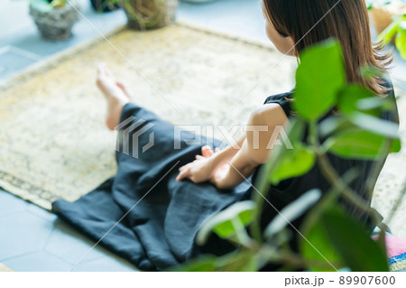 観葉植物に囲まれてリラックスする女性 89907600