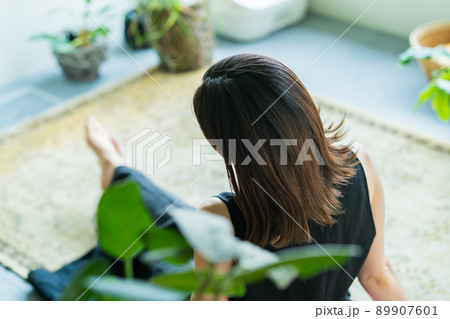 観葉植物に囲まれてリラックスする女性 観葉植物に囲まれてリラックスする女性 89907601