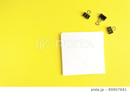 Square sheet of paper for notes. Office composition on a yellow background. Copy space 89907681