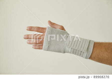 Man with tendonitis wears wrist brace that has compression and pain relief effect 89908270