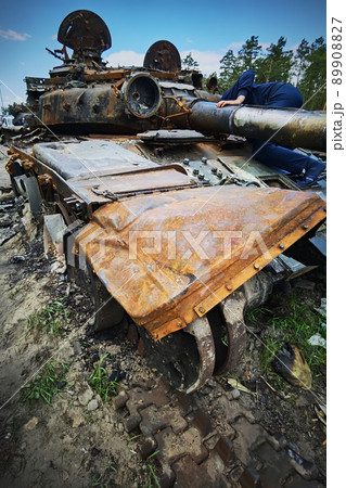 Kyiv region, Ukraine - May 15, 2022: War in Ukraine. Highway Kyiv - Zhytomyr. People take selfies against destroyed russian tank after russian atack in Febrary. 89908827