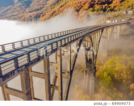 Montenegro. Dzhurdzhevich Bridge Over The River Tara foggy morning Montenegro. Dzhurdzhevich Bridge Over The River Tara foggy morning 89909073
