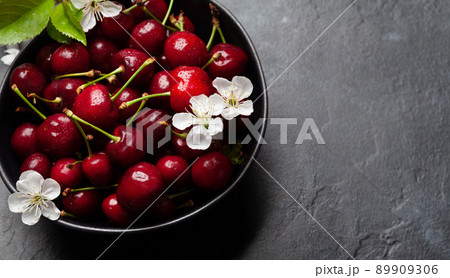 Ripe cherry in bowl with cherry blossom Ripe cherry in bowl with cherry blossom 89909306