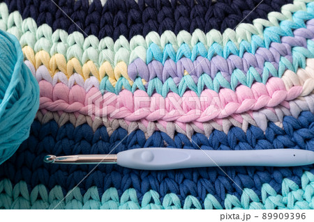 A rug made of knitted yarn and a crochet hook. Home needlework. 89909396