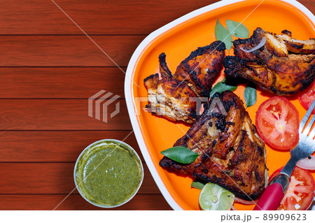 Homemade grilled, tandoori chicken served with salads and coriander mint chutney Homemade grilled, tandoori chicken served with salads and coriander mint chutney 89909623