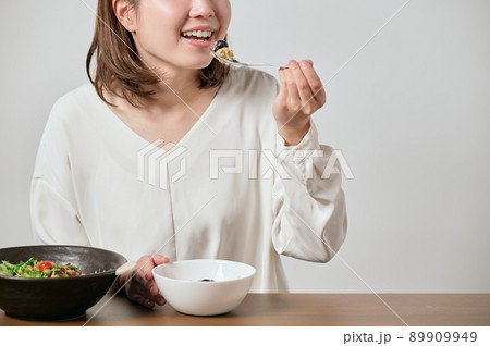 オートミールとサラダを食べる若いヴィーガン女性 89909949