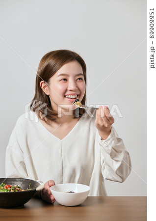 オートミールとサラダを食べる若いヴィーガン女性 89909951