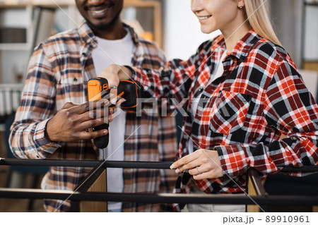 Close up of couple using screwdriver for assembling bookcase Close up of couple using screwdriver for assembling bookcase 89910961