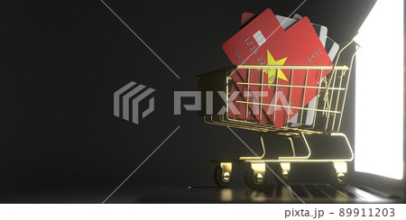 Credit card mockups with flags of Vietnam in a small shopping cart on the laptop. 3D rendering 89911203