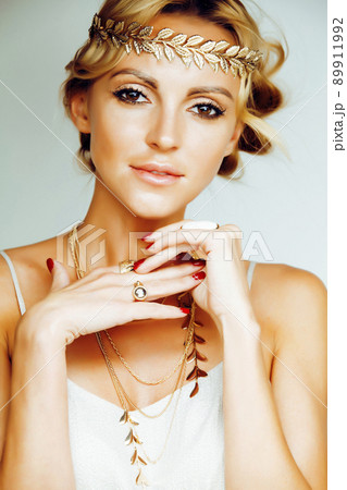 young blond woman dressed like ancient greek godess, gold jewelry close up isolated, summer trends 89911992