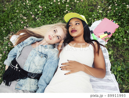 two young pretty teenager girls best friends laying on grass making selfie photo having fun, lifestyle happy people concept, students at summer close up 89911993