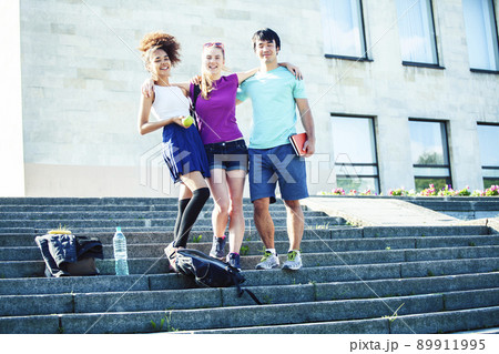cute group of teenages at the building of university with books huggings, diversity nations, having lunch closeup cute group of teenages at the building of university with books huggings, diversity nations, having lunch closeup 89911995