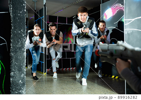 Portrait of teenager boy with laser gun having fun on dark lasertag arena 89916282