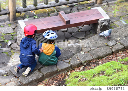 鳩に興味津々の二人の子供たち 89916751
